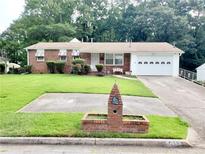 Charming brick home with a well-manicured front lawn and an attached single-car garage at 3769 Amber Nw Rd, Atlanta, GA 30331