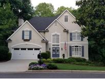 Charming two-story home featuring a well-manicured lawn, attached garage, and stately curb appeal at 6380 Bannerhorn Run, Alpharetta, GA 30005