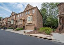 Charming multi-story townhome with a brick exterior, attached garage, and well-maintained landscaping at 2567 Willow Field Se Xing # 22, Marietta, GA 30067