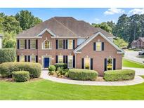 Charming brick home with manicured lawn, mature landscaping, and a welcoming blue front door at 2956 Nestle Creek Dr, Marietta, GA 30062