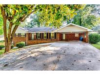 Charming brick home features a covered carport and an expansive driveway at 516 Jordan Nw Dr, Tucker, GA 30084