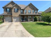 Beautiful two-story brick home with a well-manicured lawn and a two-car garage at 5290 Hidden Valley Ln, Cumming, GA 30028