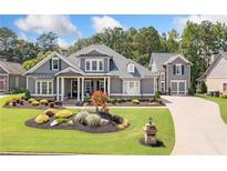 Charming home featuring professionally landscaped front yard with lush green grass and flower bed at 4875 Churchill Ridge Dr, Cumming, GA 30028