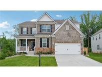 Beautiful two-story brick home with a well-manicured lawn, covered porch, and attached two-car garage at 5545 Adirondack Dr, Cumming, GA 30040