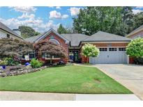 Charming brick home with a manicured lawn and lush landscaping creates a welcoming curb appeal at 510 Elgaen Ct, Roswell, GA 30075