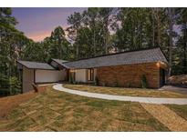Beautiful exterior elevation with stone and manicured lawn at 9025 Huntcliff Trce, Atlanta, GA 30350