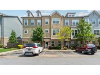 Exterior shot of a three-story townhome with a parking lot and partial green space at 2161 Colvin Ct, Atlanta, GA 30318