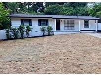 Charming single-story home featuring a white brick facade and updated landscaping at 559 Allgood Rd, Stone Mountain, GA 30083