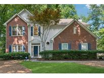 Charming two-story home featuring brick accents, classic shutters, and a well-manicured lawn at 6520 Fairfield Trce, Suwanee, GA 30024