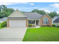 Charming single-story home featuring a well-manicured lawn and attached two-car garage at 1890 Owens Trl, Rex, GA 30273