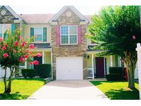 Charming townhouse with colorful shutters, a well-manicured lawn and an attached single-car garage at 7104 Georges Way, Morrow, GA 30260