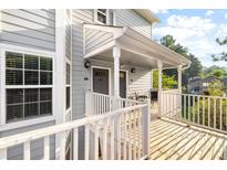 Inviting front porch featuring white railings, gray siding and doors and a peaceful, shaded sitting area at 4140 Riverlook Parkway Se Se Pkwy # 209, Marietta, GA 30067