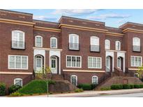 Charming brick townhomes feature front steps, petite balconies, and manicured landscaping at 5139 Peachtree Road, Chamblee, GA 30341
