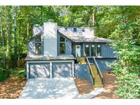 Charming home with a two-car garage, light grey paint and a staircase leading up to the front door at 3402 Devoe Ct, Marietta, GA 30062