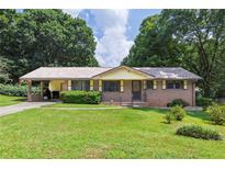 Charming single-story brick home featuring a manicured lawn and convenient carport at 434 Terrace Sw Dr, Smyrna, GA 30082