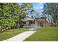 Charming brick home featuring a covered entryway, complemented by a lush green lawn at 2198 Star Mist Sw Dr, Atlanta, GA 30311