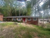 Cozy brick home featuring a red front door, large windows, and covered front porch at 481 Hammond Dr, Atlanta, GA 30328