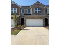 Charming townhome featuring a two-car garage and traditional brick facade at 942 Elwood St # 31, Dacula, GA 30019