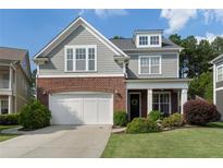 Charming two-story home boasts a brick and gray facade, complemented by a well-manicured lawn and a two-car garage at 6430 Banbury Se Ct, Mableton, GA 30126