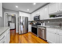 Modern kitchen with stainless steel appliances, white cabinets, and granite countertops at 22107 Harvest Ridge Lane # 22, Alpharetta, GA 30022