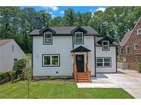 Inviting two-story home with white siding, black trim, dormer windows, and a well-manicured front lawn at 656 S Elizabeth Nw Pl, Atlanta, GA 30318