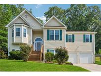 Charming home featuring a well-manicured lawn, a 2-car garage, and a inviting front porch with wood stairs at 672 Victorian Cir, Dallas, GA 30157