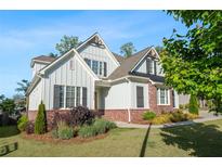 Charming two-story home with brick accents, gray siding, and meticulously manicured landscaping at 2208 Sage Mountain Sw Ct, Marietta, GA 30064