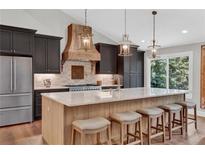 Stunning kitchen with a large island with seating, custom cabinetry, and pendant lighting at 230 Thistlewood Ln, Roswell, GA 30075