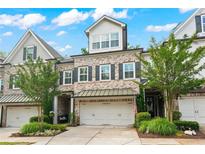 Charming townhome with brick facade, two-car garage, landscaped front yard, and mature trees at 4486 Huffman Drive Ne Dr, Roswell, GA 30075