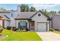 Charming home featuring a red front door, an attached garage, and well-manicured front lawn at 1269 Gates Se Cir, Atlanta, GA 30316