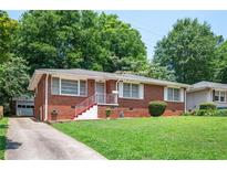 Charming brick home featuring a well-maintained front yard and a cozy entrance with red painted stairs and white railings at 2581 N Clark Dr, Atlanta, GA 30344