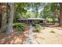 Charming single-story brick home with inviting front porch, lush landscaping, and a welcoming walkway at 4138 Hickory Dr, Powder Springs, GA 30127