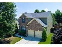 Charming two-story home featuring a brick facade, two-car garage, and a well-manicured lawn at 213 Roseman Way, Woodstock, GA 30188