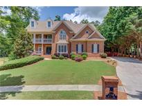 Beautiful two-story brick home with manicured lawn and covered front porch at 2748 Hidden Falls Dr, Buford, GA 30519