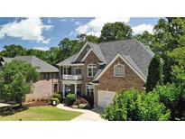Brick two-story home with a manicured lawn and mature landscaping offers curb appeal at 5059 Belair Bluff Se Ct, Smyrna, GA 30126