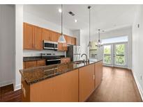 Bright kitchen features stainless steel appliances, granite countertops, and an island with a sink and breakfast bar at 425 Chapel Sw St # 1211, Atlanta, GA 30313
