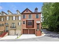 Beautiful brick townhome with two-car garage, well-maintained landscaping, and welcoming curb appeal at 1605 Pavillion Ridge Se Dr, Smyrna, GA 30080