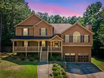 Charming two-story home with inviting front porch and well-manicured lawn surrounded by mature trees at 412 Gray Fox Dr, Canton, GA 30114