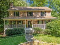 Charming two-story brick home with a welcoming front porch and lush landscaping at 786 Mitsy Pt, Marietta, GA 30068