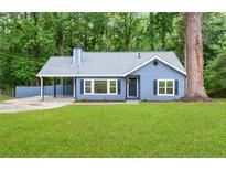 Charming, newly renovated, single-story home with an inviting exterior in a serene, wooded setting at 9025 Huntwood Ln, Riverdale, GA 30274