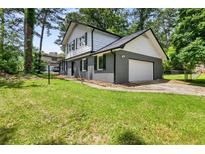 Charming two-story home featuring a gray brick exterior and well-maintained lawn at 5058 Rock Springs Rd, Lithonia, GA 30038