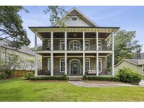 Charming two-story brick home featuring dual front porches with stately columns and manicured landscaping at 1363 Sylvan Ne Cir, Brookhaven, GA 30319