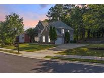 Charming two-story home boasts a well-manicured lawn and a long driveway leading to a two-car garage at 3123 Wolf Club Dr. Sw, Atlanta, GA 30349