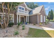 Charming brick home featuring a quaint front porch with white columns and well-manicured landscaping at 3123 Wolf Club Dr. Sw, Atlanta, GA 30349