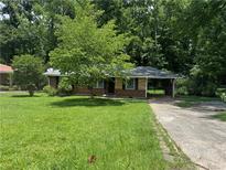 Charming brick home with a lush green front yard and a covered carport providing convenient parking at 2014 Brannen Se Rd, Atlanta, GA 30316