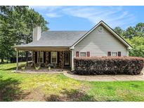 Charming home featuring a covered front porch and stone accents enhancing its curb appeal at 55 Ashland Farm Rd, Oxford, GA 30054