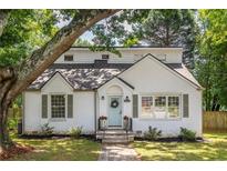 Charming brick home featuring a quaint front door, manicured lawn, and lush greenery with mature trees at 2010 2Nd Ave, Decatur, GA 30032