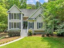Charming two-story home with stone accents, black shutters, and a well-manicured lawn at 5020 Bayberry Dr, Cumming, GA 30040