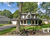Charming two-story home with a well-maintained front yard, attached garage and a pop of color with an aqua-colored front door at 8649 Cedar Creek Rdg, Riverdale, GA 30274