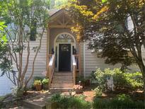 Charming front door with wooden steps and decorative wreath, surrounded by lush landscaping at 227 Bennett Farms Trl, Acworth, GA 30102